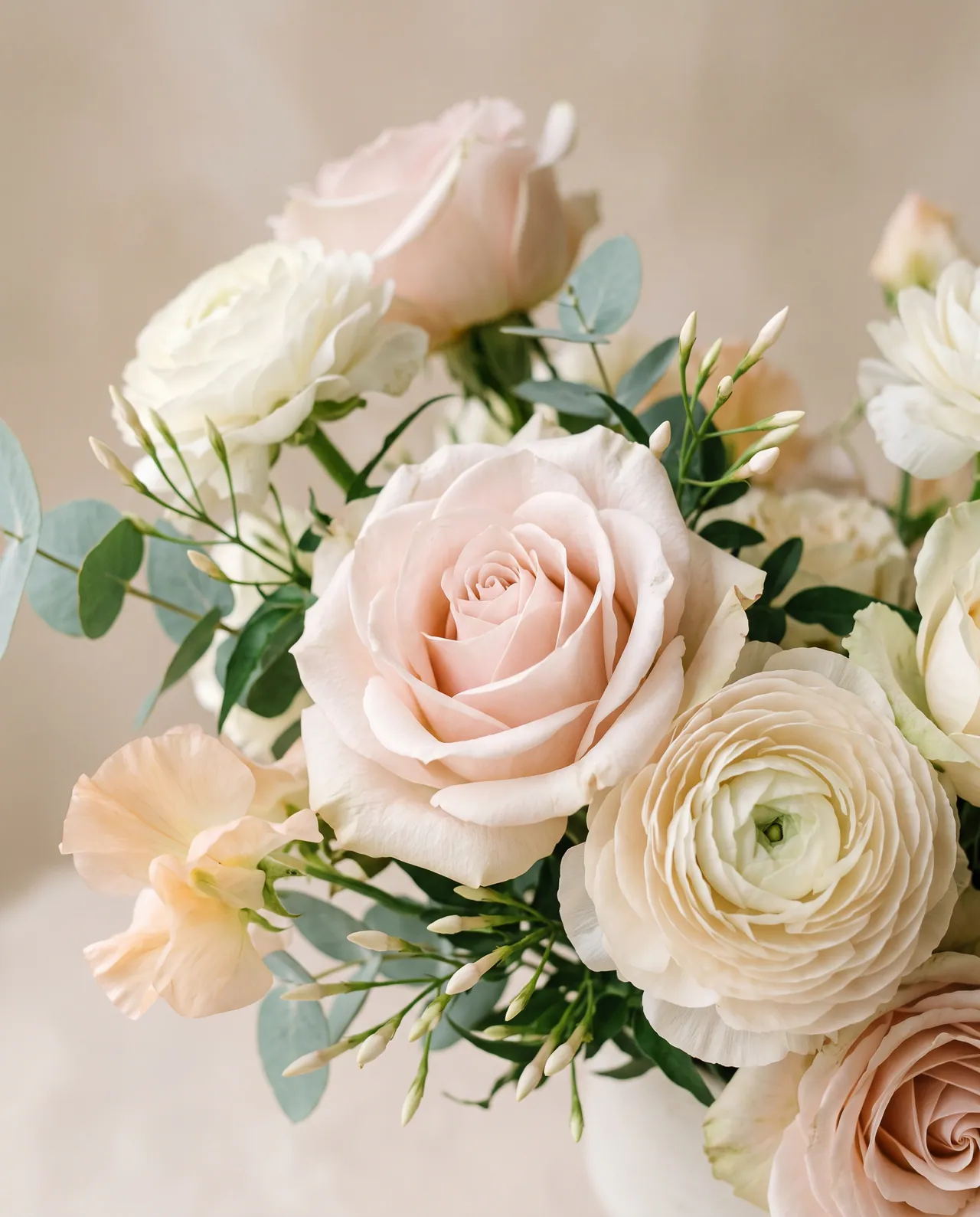 Blush roses and ranunculus with eucalyptus